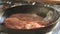 A fresh big red piece of beef is being prepared for frying a steak in a pan. Steak slow motion. Splashes of grease and