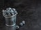 Fresh blackberries or dewberries in decorative small metal bucket on black background. Season of wild forest berries