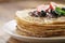 Fresh blinis or crepes with melted dark chocolate and berries