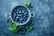 Fresh Blueberries in a bowl on dark background, top view. Juicy wild forest berries, bilberries