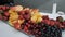 Fresh blueberries, strawberries, cherries, sliced apples, mangoes and pineapples on a long rectangular plate