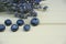 Fresh blueberries on a wooden board, dark background. Lavender. Vertical photo.