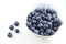 Fresh blueberry fruits in a small white bowl