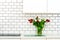Fresh bouquet of red and white tulips on kitchen table. Detail of home interior, design. Minimalistic concept. Flowers