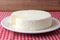Fresh brazilian white minas cheese on white plate over breakfast table with towel