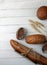 Fresh bread - buns, baguette and ears of wheat on wooden background flat lay. Vertival image