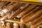 Fresh bread counter, close-up. Different types of bread loaves on wooden bakery shelves.