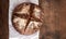 Fresh bread on dark wood board, top view. Crisp. Homemade loaf