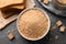 Fresh breadcrumbs in bowl on black table, flat lay