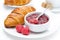 Fresh breakfast - raspberry jam and croissant on a plate