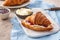 Fresh breakfast - raspberry jam and croissant on a white board.