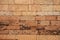 Fresh brick wall. Orange bricks closeup. Weathered grungy brick wall photo background. Distressed texture of brickwork