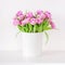 Fresh bright bouquet of pink tulip in white bucket. Beautiful greeting card. Spring holidays concept. Copyspace. Place for your te