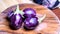 Fresh Brinjals Group  Eggplant  or Aubergine  rotating on Wooden Chopper Board