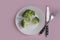 Fresh broccoli, plate fork, knife   nutritious  dietary  calories  a colored background