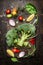 Fresh broccoli and vegetables ingredients and seasoning for tasty vegetarian cooking on rustic wooden background, top view