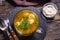 Fresh broth with dumplings in glass bowl on table above