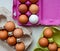 Fresh brown and white eggs in multicolored cardboard containers, top view
