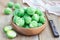 Fresh brussels sprouts in a bowl on wooden background, horizontal