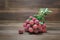 Fresh bunch of lychee fruit Litchi chinensis on wooden background.