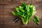 Fresh bundle of spinach on rustic wooden background