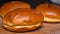 Fresh buttered brioche buns on a chopping board