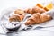 Fresh buttery croissants marmalade and oranges on kitchen table