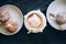 Fresh cappuccino art with two plates with tasty cakes.