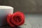Fresh cappuccino with red rose on wood table