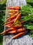 Fresh carrots in sunny day on wooden table background