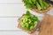 Fresh celery sliced in bowl with bunch celery on white wood background. Top view and Copy space