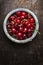 Fresh cherries berries in blue bowl on dark rustic wooden background