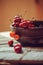 Fresh cherries close up in clay handmade plate on wooden table