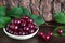 Fresh cherries in a dish on wooden table. cherry tree branch, sweet cherries