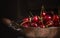 Fresh cherries in old copper pan on dark background, close up
