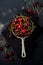 Fresh cherry berries in rustic aluminum pan on dark concrete old background. Top view