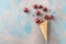 Fresh cherry fruits and ice cubes coming out from ice cream cone