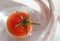 Fresh cherry tomato floats in water and bubbles as a top view background