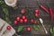 Fresh cherry tomatoes, basil and chili pepper on the wooden table, top view