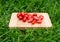 Fresh cherry tomatoes on the old wooden cutting board, closeup food, outdoors shot.