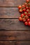 Fresh cherry tomatoes on twigs on wooden table