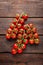 Fresh cherry tomatoes on twigs on wooden table