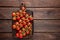 Fresh cherry tomatoes on twigs on wooden table