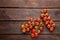 Fresh cherry tomatoes on twigs on wooden table