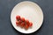 Fresh cherry tomatos in the bowl on the dark stone background