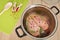 A fresh chicken breast in a pot on the slightly blue glass table