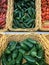 Fresh chillies variety piled in the baskets on the market. Jalapeno pepper with some Birdseye chillies and Habanero chillies on