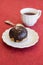 Fresh chocolate donut on a napkin with a cup of tea