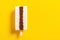 Fresh chocolate and milkshake flavor popsicle on a yellow background with copy space