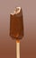 a fresh chocolate outer popsicle with blueberry sauce inside with a bite on brown background